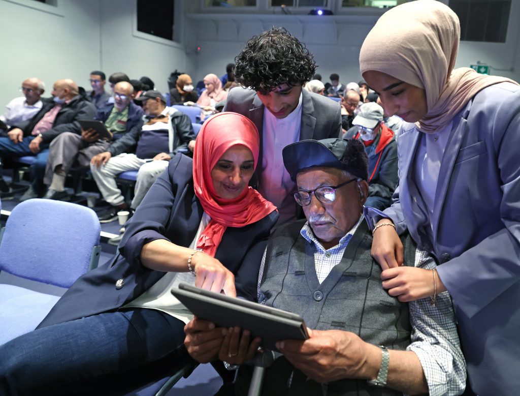 Yemeni people looking at a digital tablet